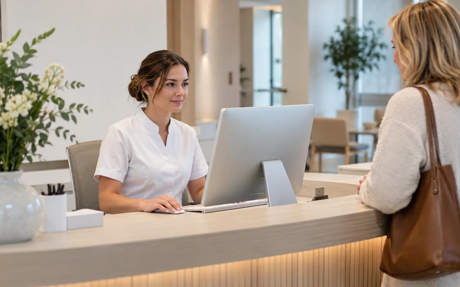 Illustration: Receptionist using an all-in-one PC at a reception desk.