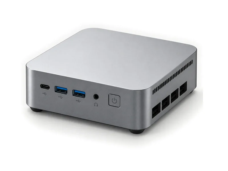 Gray mini PC with blue USB sockets and square power button on a light studio background