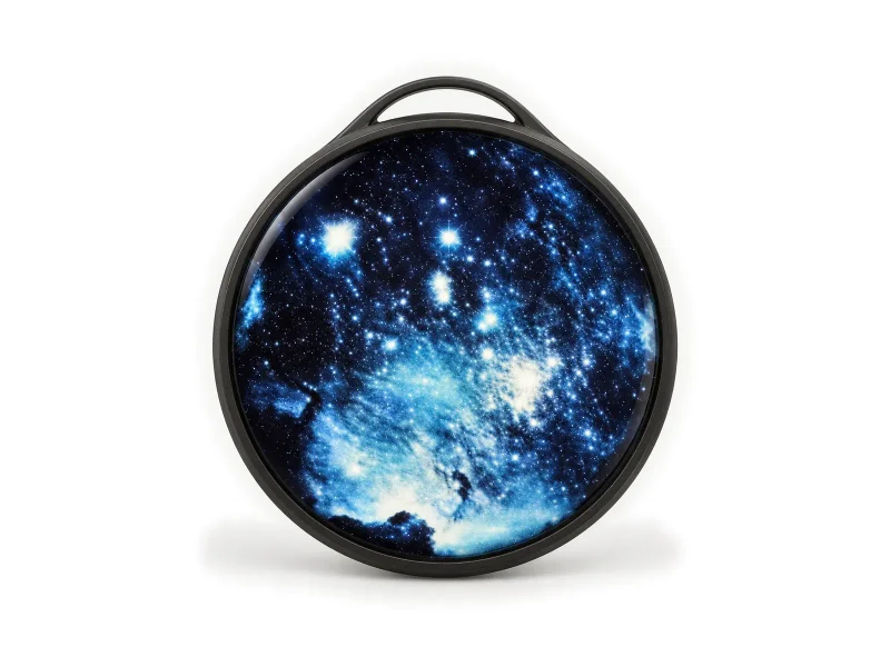 Round dark digital badge with galaxy display and hanging loop on a light studio background