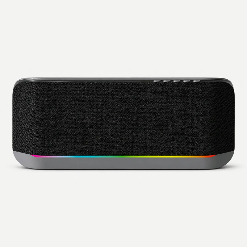Black oblong wall speaker with gray lower base and thin rainbow light line on a light studio background