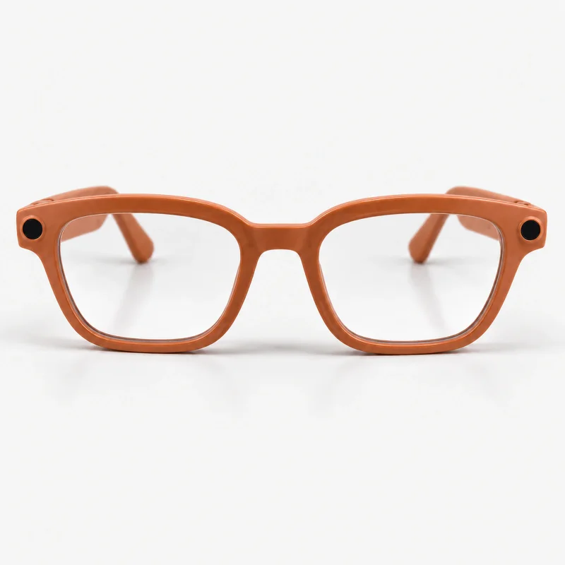 Orange camera glasses with clear lenses on a light studio background