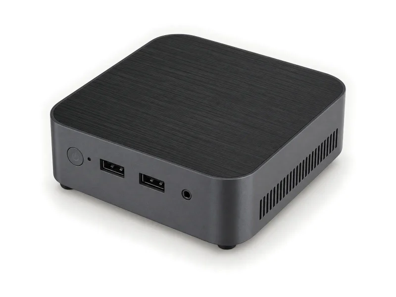 Dark grey mini PC with fine-lined black top and two black USB-A ports on a light studio background