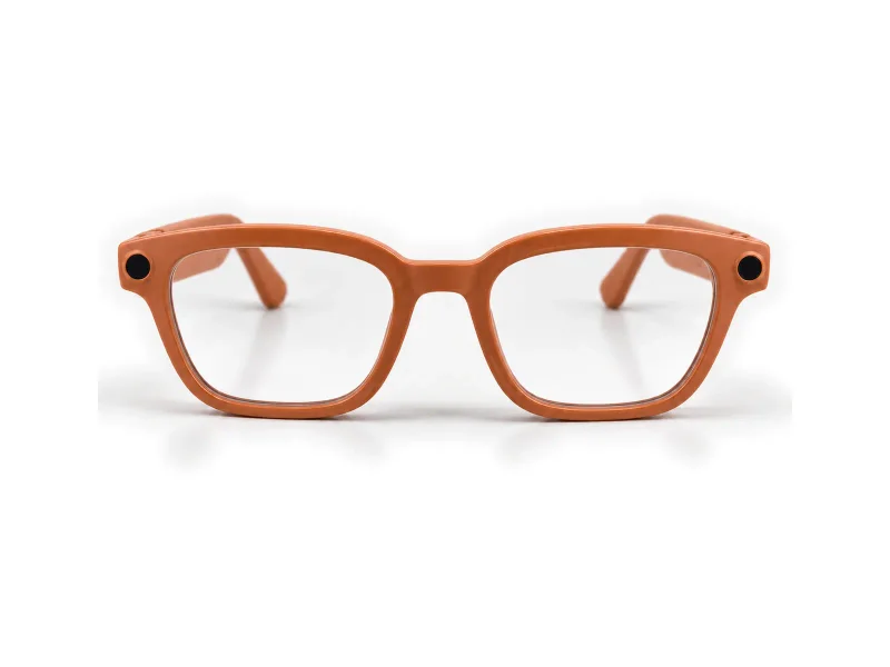 Orange camera glasses with clear lenses on a light studio background