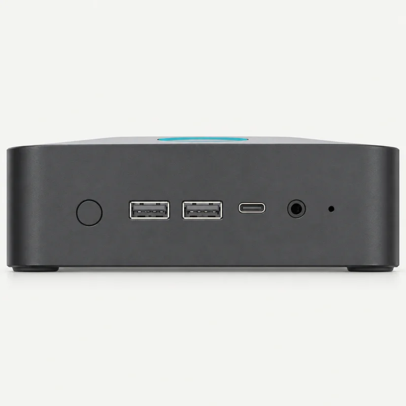 Compact graphite mini PC with round power button, two front USB-A, USB-C and audio on a light studio background